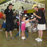BikeTexas Executive Director enlists a small helper in the bike raffle drawing.